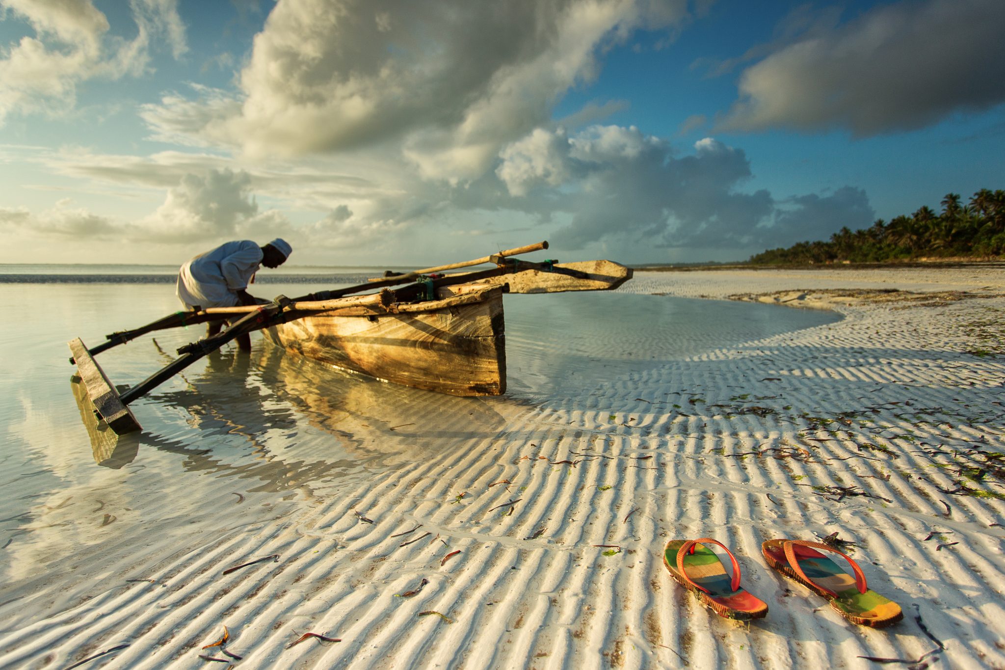 Undiscovered destinations- Traditional fisher boat in Zanzibar with people going to fish on low tide