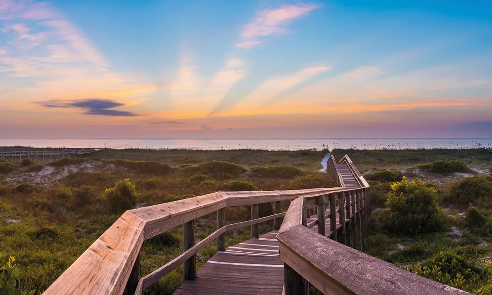 A bridge stretches across a field into the sunset on Amelia Island
