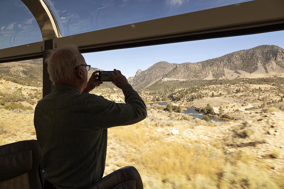 A guest photographs the landscape from the moving Canyon Spirit train.
