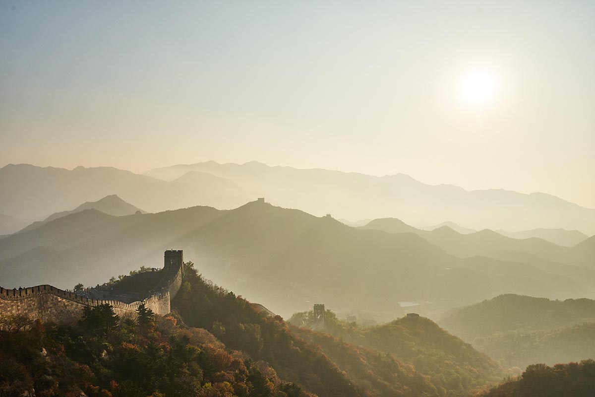 Sunshine over a landscape featuring the Great Wall of China.
